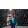 Mature businessman using tablet in a high rack warehouse of a factory