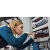 Female electrician working on circuitry in workshop